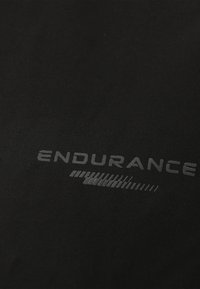 Schwarzes Sporthemd aus Stoff mit einem reflektierenden grauen "ENDURANCE"-Logo, glatter Textur und subtiler Schattierung.
