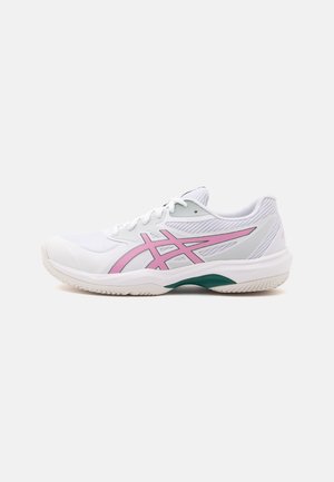 Chaussure de sport blanche avec des accents roses et verts, empeigne en mesh et design à lacets sur un fond gris clair uni.