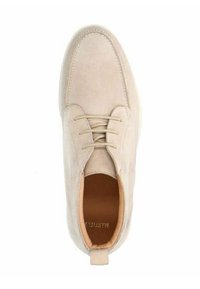 Chaussure en suède beige avec un bout rond, cinq trous pour lacets et un intérieur texturé. Équipée d'une boucle au talon pour un enfilage facile.