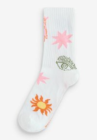 Baltos dryžuotos kojinės su spalvingais siuvinėtiais raštais: oranžinė saulė, rožinės žvaigždės ir žalias akies raštas.