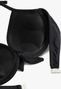 Reggiseno imbottito nero con tessuto liscio, spalline regolabili e chiusura ad uncino; presenta un design della coppa sagomato per un sostegno ottimale.