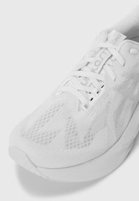 Chaussure de course Asics blanche avec tige en mesh, lacets attachés et semelle rembourrée, affichant le logo "FF Blast" sur la semelle intermédiaire et la languette.
