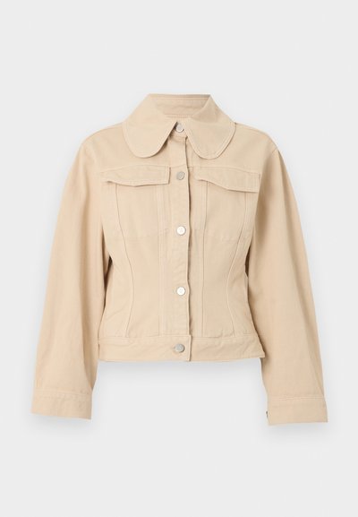 Μπεζ κοντό σακάκι με κλείσιμο με κουμπιά μπροστά, μεγάλο στρογγυλεμένο γιακά, μακριά μανίκια και δύο τσέπες στο στήθος με καπάκι.