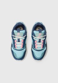 Une paire de baskets de sport bleues et marine avec des lacets blancs et des accents roses, vue de dessus sur un fond blanc.