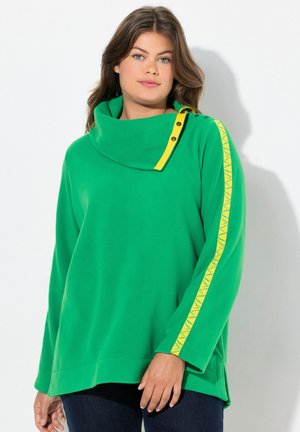 Sweatshirt en molleton vert avec un col montant, des accents de boutons jaunes et une bande à motifs jaunes le long des manches. Coupe décontractée.