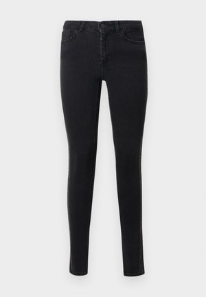 Mustat kapeat farkut, jotka on valmistettu sileästä denimmateriaalista. Ominaisuuksiin kuuluvat etutaskut ja koristeellinen ommel sivusaumojen varrella.
