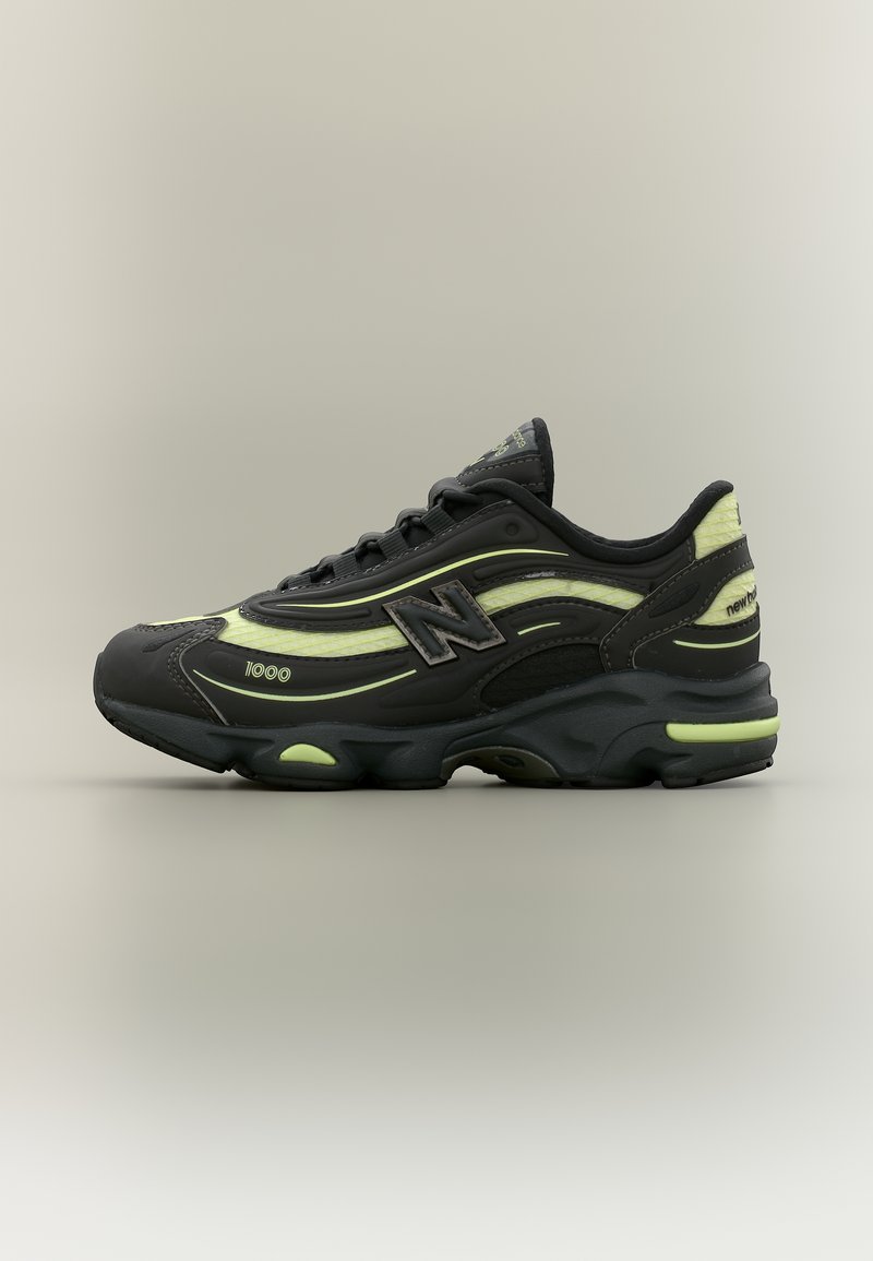 Μαύρο και νέον πράσινο αθλητικό παπούτσι New Balance 1000 με χοντρή σόλα, κορδόνια μπροστά και λογότυπο "N" στη πλευρά και στη φτέρνα.
