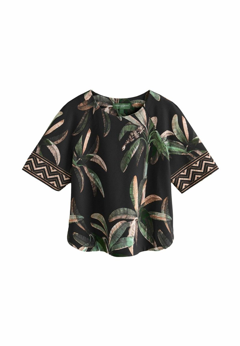 Camiseta de manga corta con un fondo negro y patrones de hojas en verde y beige, complementada con acentos estampados en las mangas.