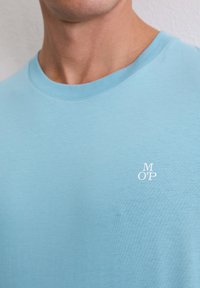 Lichtblauw T-shirt met korte mouwen, gemaakt van zacht katoen, met een subtiel wit logo geborduurd op de borst. Klassiek T-shirt met ronde hals.