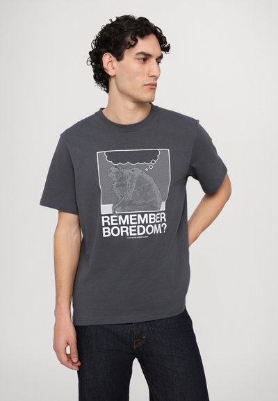 Gray cotton t-shirt with a crew neck and short sleeves. Front features a graphic with text “REMEMBER BOREDOM?” in white.