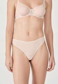 Reggiseno rosa chiaro e perizoma abbinato, realizzati in materiale a rete trasparente. Il design presenta una finitura liscia con bande in contrasto.