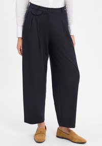 Schwarze, maßgeschneiderte Hose mit hoher Taille, versehen mit Falten, flachem Vorderteil und Seitentaschen, aus glattem Stoff. Akzentuiert mit zwei Knöpfen.