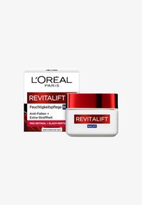 L'Oréal Revitalift nattkräm i en vit burk med rött lock. Förpackningen har en röd och svart design; texten framhäver anti-rynkegenskaper.