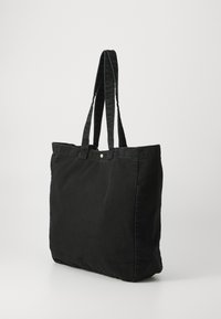 Borsa a spalla in tela nera con due manici robusti, una forma rettangolare semplice e un bottone visibile nella parte superiore.