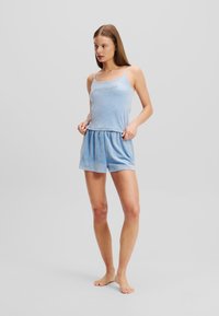 Svetlomodrá súprava loungewear obsahujúca top bez rukávov s vyšitými detailmi a voľné šortky s elastickým pásom. Mäkká tkanina.