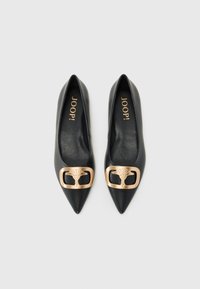 Ballerines noires en cuir à bout pointu avec une grande boucle décorative en métal doré au design floral ; texture lisse, accents minimaux.