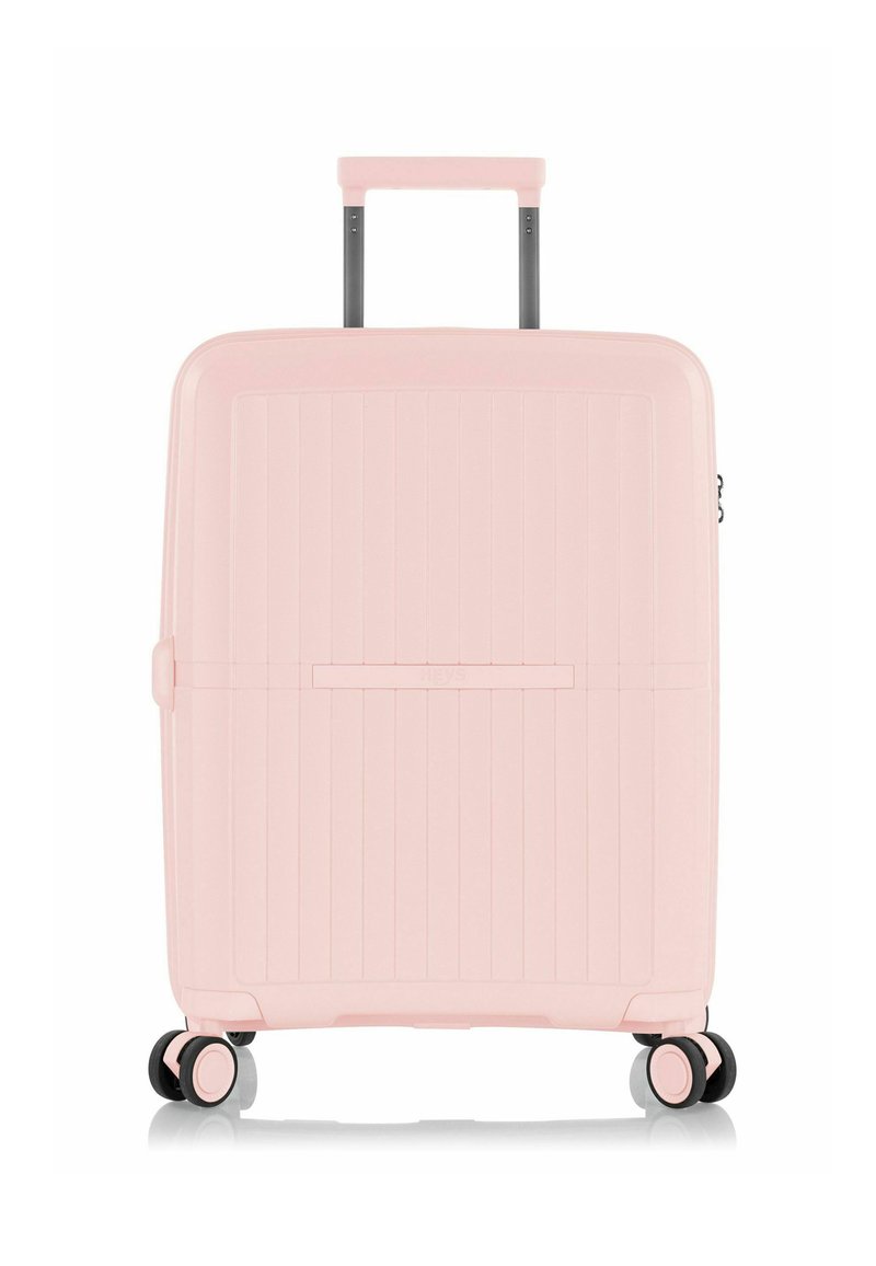 Maleta de hard-shell en rosa pastel, de forma rectangular, con textura estriada vertical, mango retráctil y cuatro ruedas para una mayor movilidad.