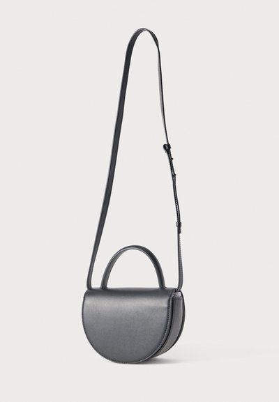 Γκρι δερμάτινη τσάντα χειρός με στρογγυλεμένο σχήμα, επίπεδη πρόσοψη και πάνω λαβή. Διαθέτει μακρύ ρυθμιζόμενο λουρί και λεία υφή.