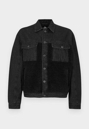 Sort denimjakke med et frontpanel i kunstpels. Har to brystlommer, knaplukning og lange ærmer. Tekstureret stof og rene linjer.