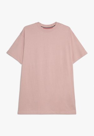 Camiseta lisa de color rosa claro, de manga corta y cuello redondo, con un ajuste relajado, mostrada estirada sobre un fondo blanco.