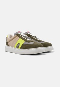 Green and beige sneakers featuring a vibrant yellow accent, textile and suede materials, white laces, and a chunky white sole.