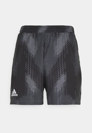 Pantalones cortos deportivos negros con un patrón geométrico, acabado texturizado y cintura elástica, decorados con un logo blanco en el lado izquierdo.