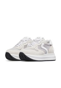 Des baskets gris clair présentant un mélange de suède et de matériaux en maille, un logo blanc et une épaisse semelle noire avec une touche de gris.