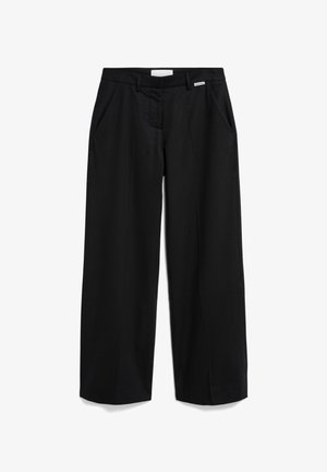 Schwarze weit geschnittene Hosen mit einer glatten Textur, ausgestattet mit seitlichen Taschen, einem Reißverschluss und einem kleinen weißen Etikett am Bund.