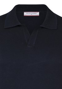 Tumedate sinine polo särk, millel on tekstuuriga kangas, klassikaline krae ja kolme nööbiga lähenemine. Etikett kannab nime "FELIX HARDY."