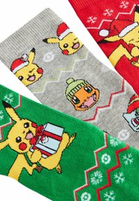 Tre paia di calzini colorati: rossi con fiocchi di neve, grigi con Pikachu e Charmander, verdi con Pikachu che tiene un regalo. Misto cotone.