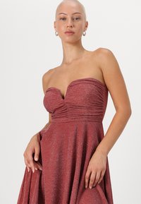 Rihmatu pehmendatud bodice õhtukleit metallik burgundia kangast. Voogav seelik, millel on peen sära, vöökoht on sobiv, sile tekstuur.