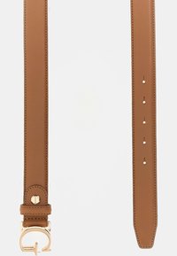 Tan leather belt featuring a smooth finish, gold-tone hardware, and five adjustable holes. The end is tapered for a sleek design.