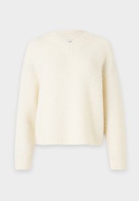 Kremfarget, oversized genser med V-hals, ribbestrikkede mansjetter og kant. Laget av et mykt, teksturert strikket stoff. Ledig passform med senkede skuldre.
