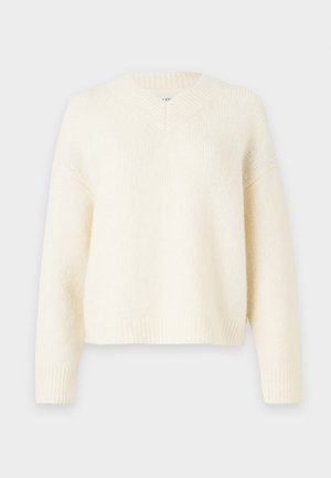 Krémový oversized svetr s V-výstřihem, žebrovanými manžetami a lemováním. Vyrobený z měkké texturované pleteniny. Uvolněný střih s kleslými rameny.