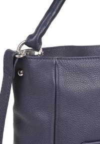 Borsa a tracolla in pelle blu navy con finitura texturizzata, hardware in argento e una singola maniglia fissata con un anello. Presenta un design strutturato e liscio.