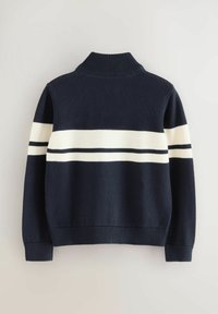 Dunkelblauer Strickpullover mit hohem Kragen, der einen breiten weißen Streifen und zwei dünne dunkelblaue Streifen über die Brust und die Ärmel hat.