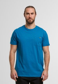 Blaues T-Shirt mit kurzen Ärmeln und rundem Ausschnitt, aus weichem Material gefertigt, mit einer linken Brusttasche und dekorativem Streifendetail.