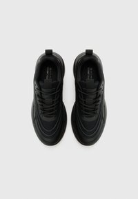 Black sneakers featuring a layered design with a mesh upper and textured sole. Includes black laces and a pull tab on the heel.