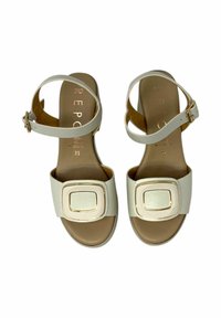 Sandali in pelle beige con cinturino alla caviglia, dettaglio con fibbia metallica quadrata e finitura opaca e liscia sulla tomaia e sulla soletta. Taglia 35.