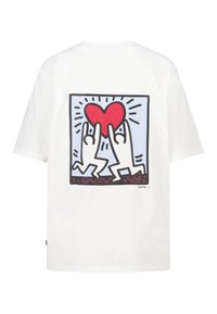 Witte katoenen t-shirt met op de achterkant een afbeelding van twee gestileerde handen die een rood hart omhoog houden tegen een blauwe achtergrond.