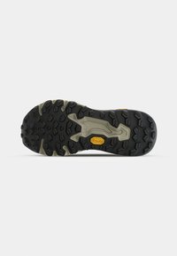 Semelle Vibram avec des crampons profonds pour une meilleure adhérence, présentant une base noire et des accents gris. Inclut un logo Vibram jaune au centre.