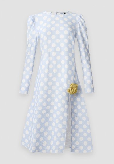 Rochie albastră deschisă cu buline albe mari, mâneci lungi, țesătură texturată și un accent de trandafir galben la talie.