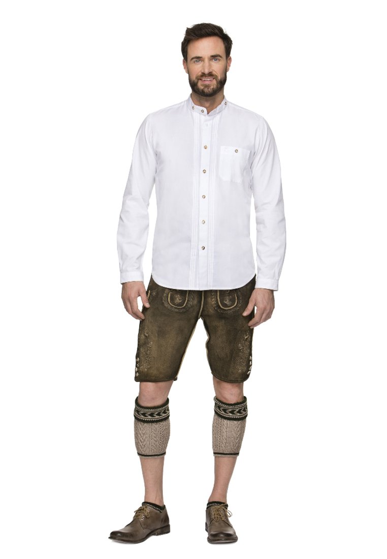 Weißes Langarmhemd mit Knöpfen und Tasche, kombiniert mit braunen Lederhosen, die mit Stickereien verziert sind, und knielangen Stricksocken.