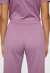 Lila katoenen sweatpants met een elastische tailleband. Glad textuur en een ontspannen pasvorm, met stikdetails langs de tailleband en naden.
