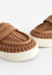 Bruna vävda läderskor med rund tå och elastiskt band, med en texturerad vit gummisula.