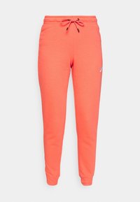 Korallfärgade Nike-joggers med elastisk midja, dragsko, muddar vid anklarna och liten vit Nike-logotyp på vänster lår.