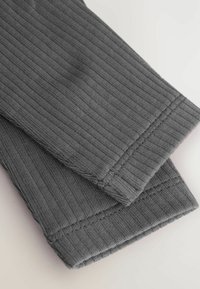 Gray ribbed fabric with a textured surface, featuring visible stitching along the edges and folded cuffs, displaying a soft finish.