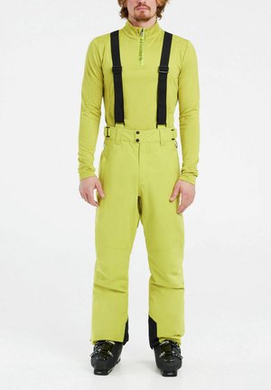 Esquí con un traje de color lima brillante con tirantes negros, cuello con cremallera y tejido impermeable. Presenta un corte relajado y un diseño de pierna ancha.