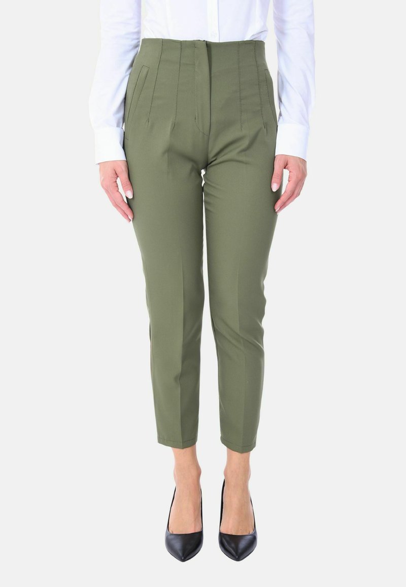 Pantaloni su misura verde oliva con vita alta, pieghe, tasche anteriori e gamba affusolata, abbinati a décolleté nere a punta.