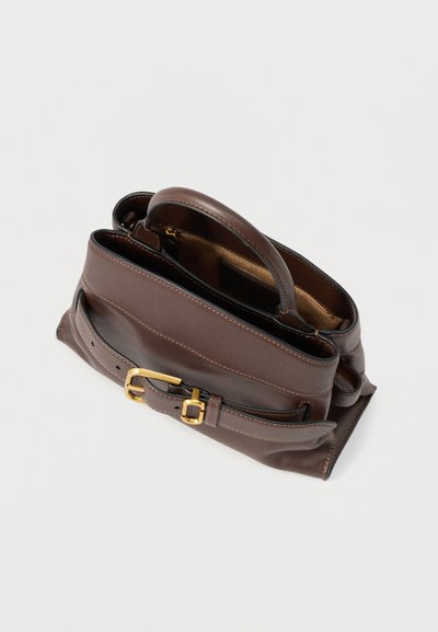 Καφέ δερμάτινη τσάντα με δομημένο σχήμα, χρυσά μεταλλικά στοιχεία, χειρολαβές στην κορυφή και αποσπώμενο λουρί. Διαθέτει διακοσμητικές ραφές και ανοιχτή κορυφή.